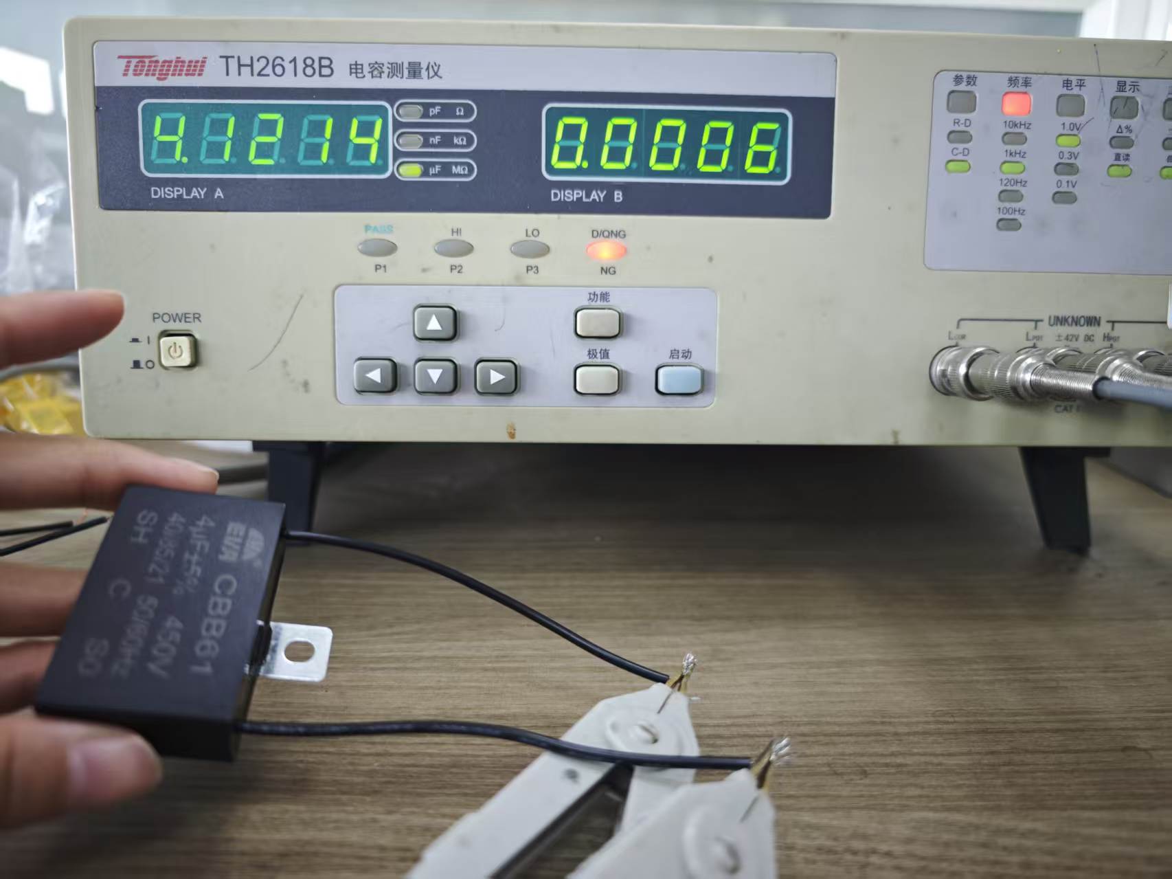 Measured capacitance of CBB61 4uF capacitor showing 4.12uF during factory inspection